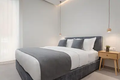 a bedroom with a large bed and a wooden table at Athens Luxury Ethereal Stay in Athens