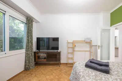 a bedroom with a bed and a tv and a window at Stylish Luxury Apartment at Ampelokipi metro station in Athens