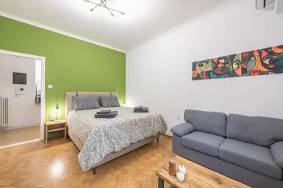 a bedroom with a bed and a couch at Stylish Luxury Apartment at Ampelokipi metro station in Athens