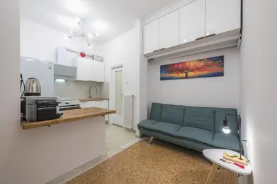a living room with a green couch and a kitchen at Stylish Luxury Apartment at Ampelokipi metro station in Athens