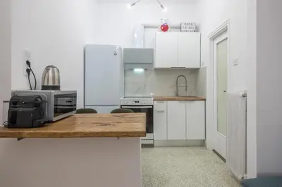 a kitchen with white cabinets and a table with a microwave at Stylish Luxury Apartment at Ampelokipi metro station in Athens