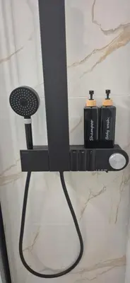 a bathroom shelf with two black bottles on it at Stylish Luxury Apartment at Ampelokipi metro station in Athens