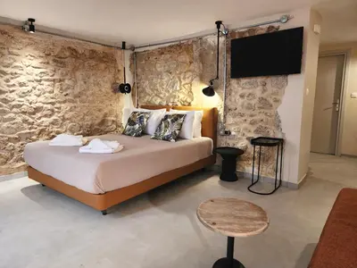 a bedroom with a bed and a tv on a wall at Emerald House Rooftop & Stylish Apartments In Central Athens in Athens