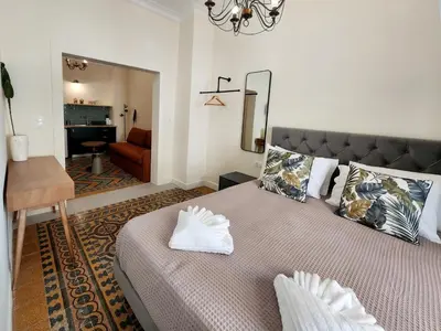 a bedroom with a bed and a chair and a mirror at Emerald House Rooftop & Stylish Apartments In Central Athens in Athens