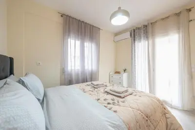 a bedroom with a bed and a large window at Casa Ilioupoli in Athens
