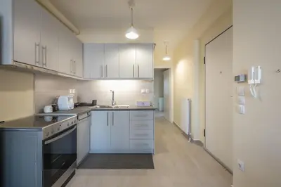 a large kitchen with white cabinets and appliances at Casa Ilioupoli in Athens