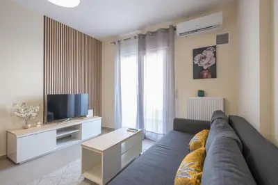 a living room with a couch and a tv at Casa Ilioupoli in Athens