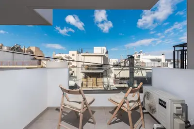two chairs on a balcony with a view of a city at Casa Ilioupoli in Athens