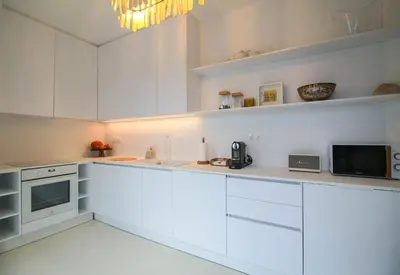 a white kitchen with white cabinets and a microwave at Bunny Island Exquisite Villas in Lagonissi