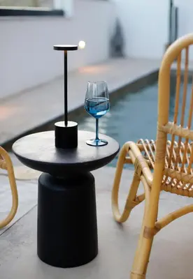 a wine glass on a table next to a pool at Bunny Island Exquisite Villas in Lagonissi