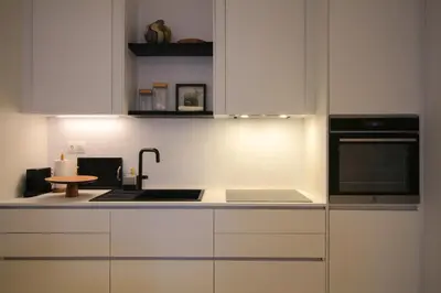 a kitchen with white cabinets and a sink and a stove at Bunny Island Exquisite Villas in Lagonissi