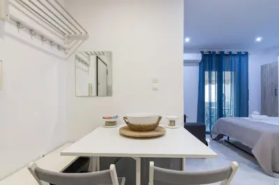 a white room with a table and chairs and a bed at Modern Studio in Piraeus in Piraeus