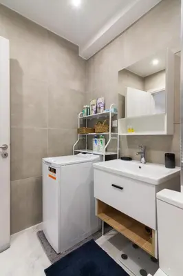 a bathroom with a white sink and a mirror at Modern Studio in Piraeus in Piraeus
