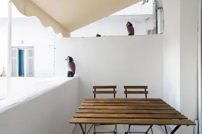 two benches sitting on a wall next to a wooden table at Modern Studio in Piraeus in Piraeus