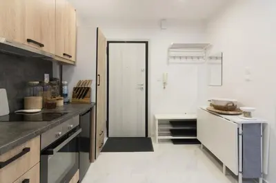 a kitchen with white walls and wooden cabinets at Modern Studio in Piraeus in Piraeus