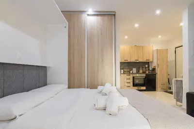 a bedroom with a large white bed with towels on it at Modern Studio in Piraeus in Piraeus