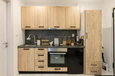 a kitchen with a black oven and wooden cabinets at Modern Studio in Piraeus in Piraeus