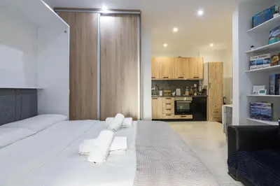 a bedroom with a white bed with towels on it at Modern Studio in Piraeus in Piraeus
