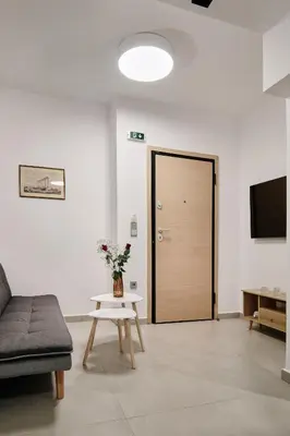 a living room with a couch and a table and a door at La Stella Apartment Thisio in Athens