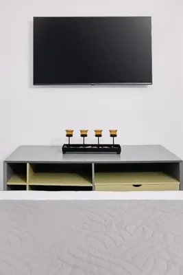 a table with a television on a white wall at La Stella Apartment Thisio in Athens