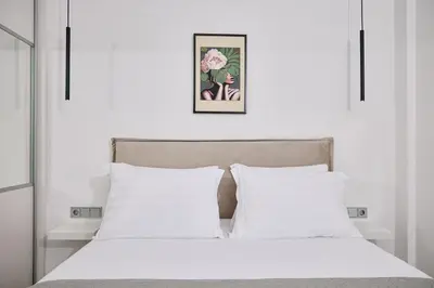 a bedroom with a white bed with two pillows at La Stella Apartment Thisio in Athens