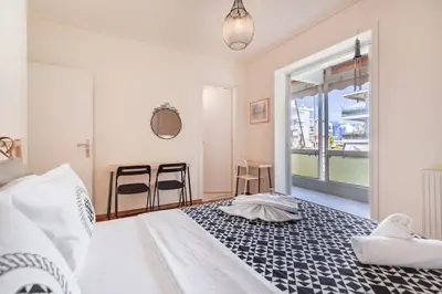 a bedroom with a bed and a large window at Kalamaki Beach Apartment in Athens