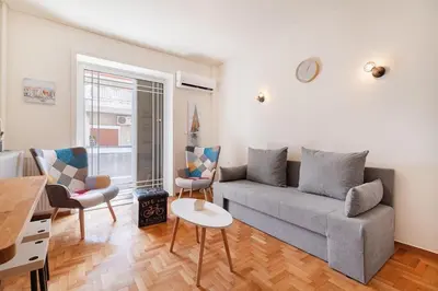 a living room with a couch and chairs and a table at Kalamaki Beach Apartment in Athens