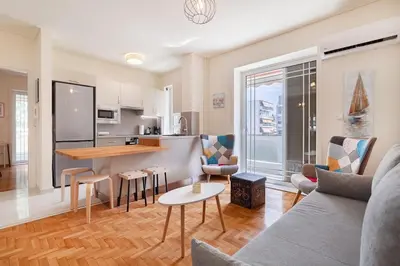 a living room with a couch and a kitchen at Kalamaki Beach Apartment in Athens