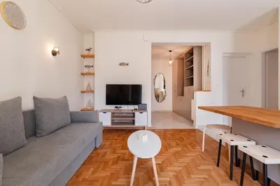 a living room with a couch and a table at Kalamaki Beach Apartment in Athens