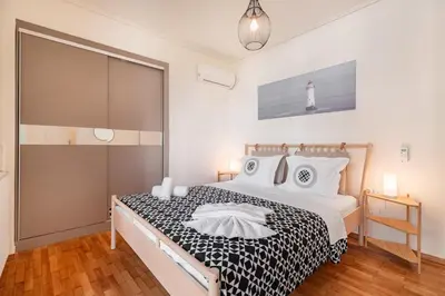 a bedroom with a black and white bed and a lighthouse at Kalamaki Beach Apartment in Athens