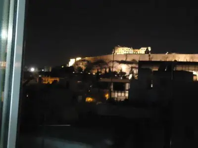 a view of a lit up building at night at Super central loft - Acropolis metro, museum in Athens