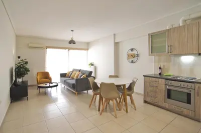 a kitchen and living room with a table and a couch at Oasis Neos Kosmos Modern Apt near Acropolis in Athens