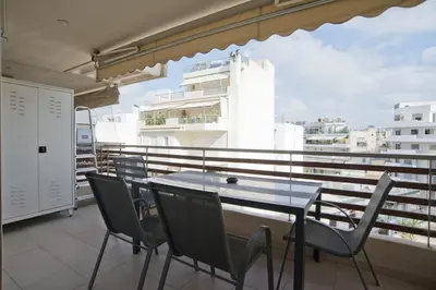 a table and chairs on the balcony of a building at Oasis Neos Kosmos Modern Apt near Acropolis in Athens