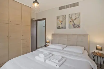 a bedroom with a white bed with towels on it at Oasis Neos Kosmos Modern Apt near Acropolis in Athens
