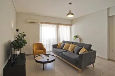 a living room with a couch and a table at Oasis Neos Kosmos Modern Apt near Acropolis in Athens