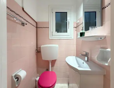 a pink bathroom with a pink toilet and a sink at Athina in Athens 5 min to Metro Station in Athens
