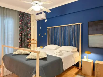 a bedroom with a bed with a blue wall at Athina in Athens 5 min to Metro Station in Athens