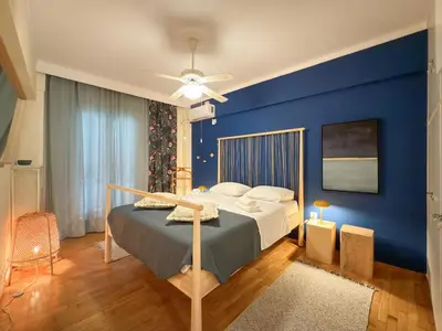 a blue bedroom with a bed and a blue wall at Athina in Athens 5 min to Metro Station in Athens