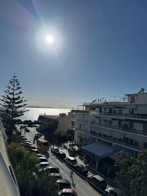 a parking lot with cars parked in front of a building at Athens Riviera Sea in Athens