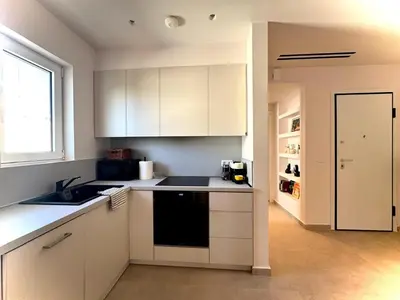 a kitchen with white cabinets and a sink and a window at Athens Riviera Sea in Athens