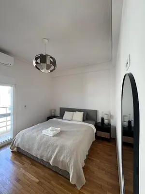 a white bedroom with a bed and a mirror at Athens Riviera Sea in Athens
