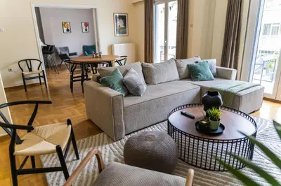 a living room with a couch and tables and chairs at 3BD Family Comfort Stay in Athens