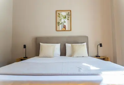 a bed with white sheets and pillows in a bedroom at 3BD Family Comfort Stay in Athens