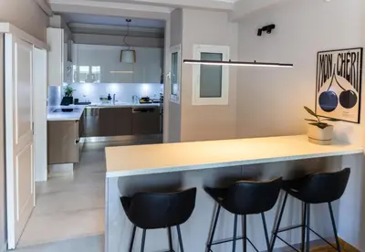 a kitchen with a counter and stools around it at 3BD Family Comfort Stay in Athens