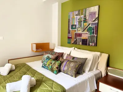 a bedroom with green walls and a bed with pillows at Arthome Acropolis Spot in Athens