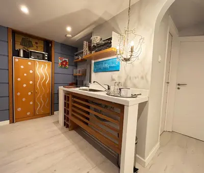 a kitchen with a counter with a sink and a refrigerator at Arthome Acropolis Spot in Athens