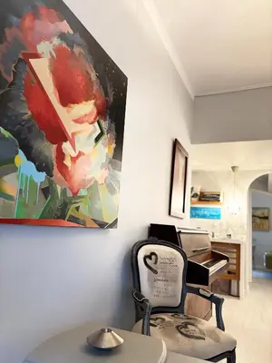 a painting hanging on a wall next to a chair at Arthome Acropolis Spot in Athens