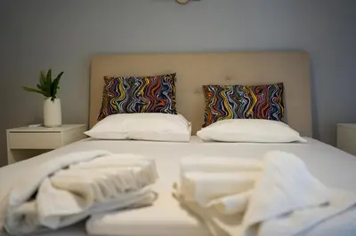 a bed with two pillows and towels on it at Ilysia's Retreat, Cozy 1 BDRM Apartment in Athens