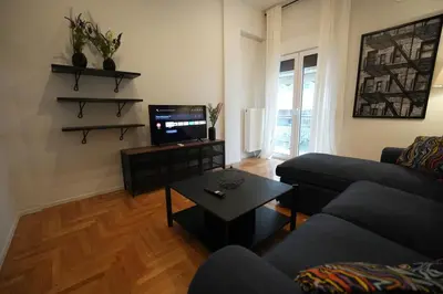 a living room with a couch and a tv at Ilysia's Retreat, Cozy 1 BDRM Apartment in Athens