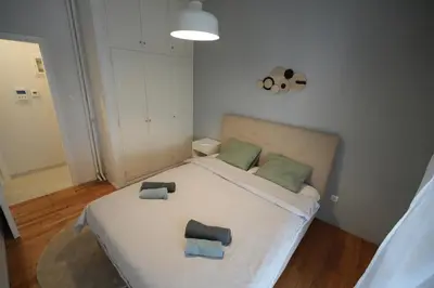 a bedroom with a large white bed with two pillows at Ilysia's Retreat, Cozy 1 BDRM Apartment in Athens